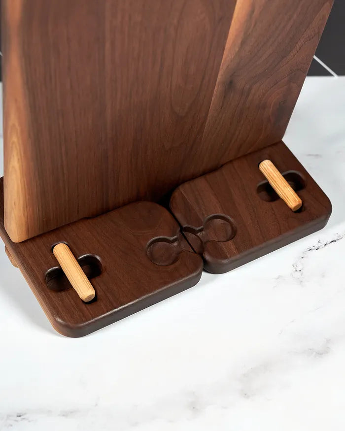 Rear view of a walnut cookbook stand showing the one-piece ledge and foot and the dowel rod holders.