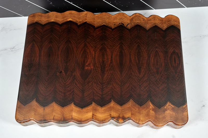 Bolivian rosewood live edge butcher block by Kineo Mountain Woodsmithing, 17x13 inches, showing natural wood grain and smooth edges.