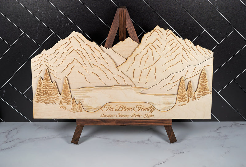 Family Mountains wooden wall art decor by Kineo Mountain Woodsmithing featuring carved mountain silhouettes and a family name inscription.