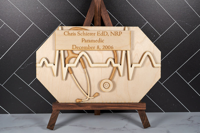 Wooden commemorative wall art decor by Kineo Mountain Woodsmithing featuring intricate carved designs on natural wood surface.