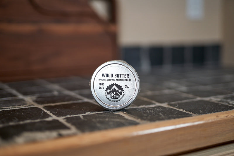 Kineo Mountain Woodsmithing Wood Butter 3oz jar, natural wood finishing product, with wood grain and product label visible in the image.