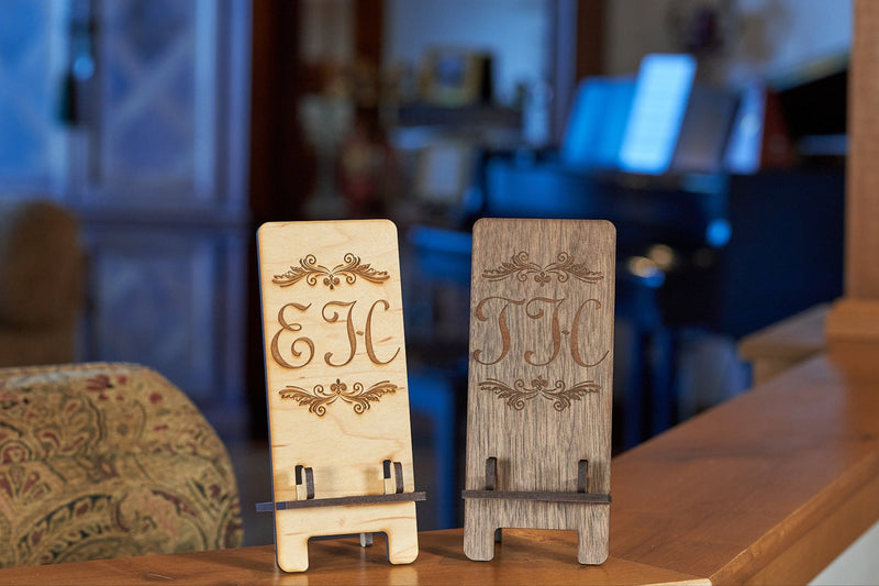 Kineo Mountain Woodsmithing Eagle River Phone Stand made of wood, holding a smartphone in a sleek, natural finish.