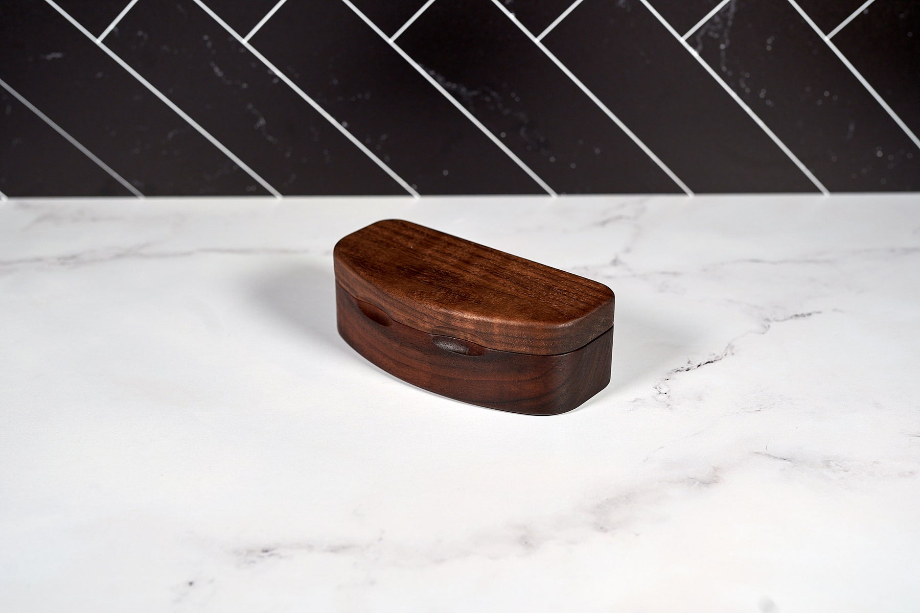 Kineo Mountain Woodsmithing sunglasses case made of durable wood, designed to protect and store sunglasses securely.