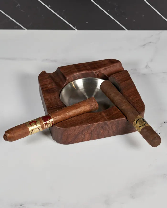 Black walnut cigar ashtray holding four cigars over a brushed stainless steel dish.