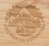 Signature GrainView laser engraving of the Kineo logo on maple with visible wood grain.