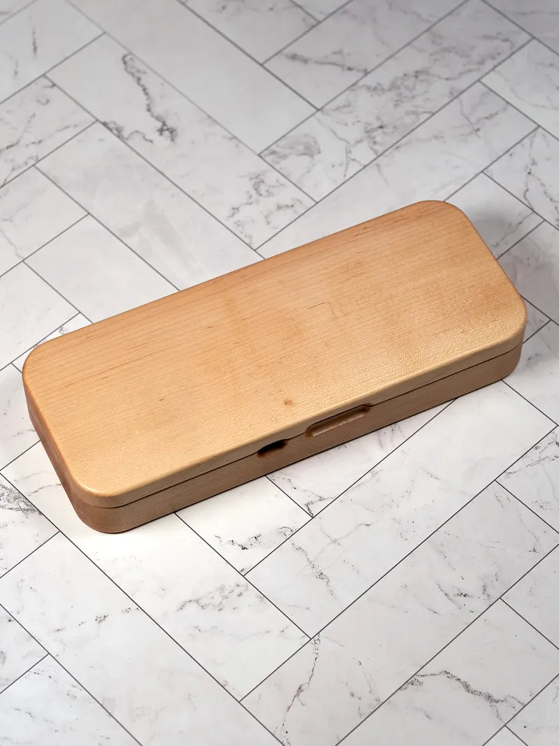 Hard maple Nintendo Switch 2 travel case closed on a white marble surface.