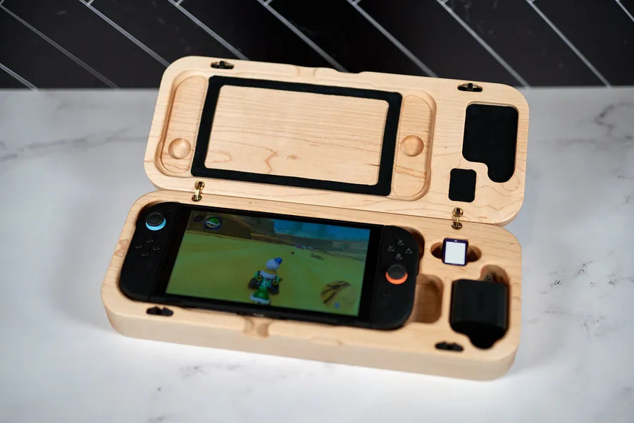 Hard maple travel case open on a marble counter with a Nintendo Switch 2 inside.