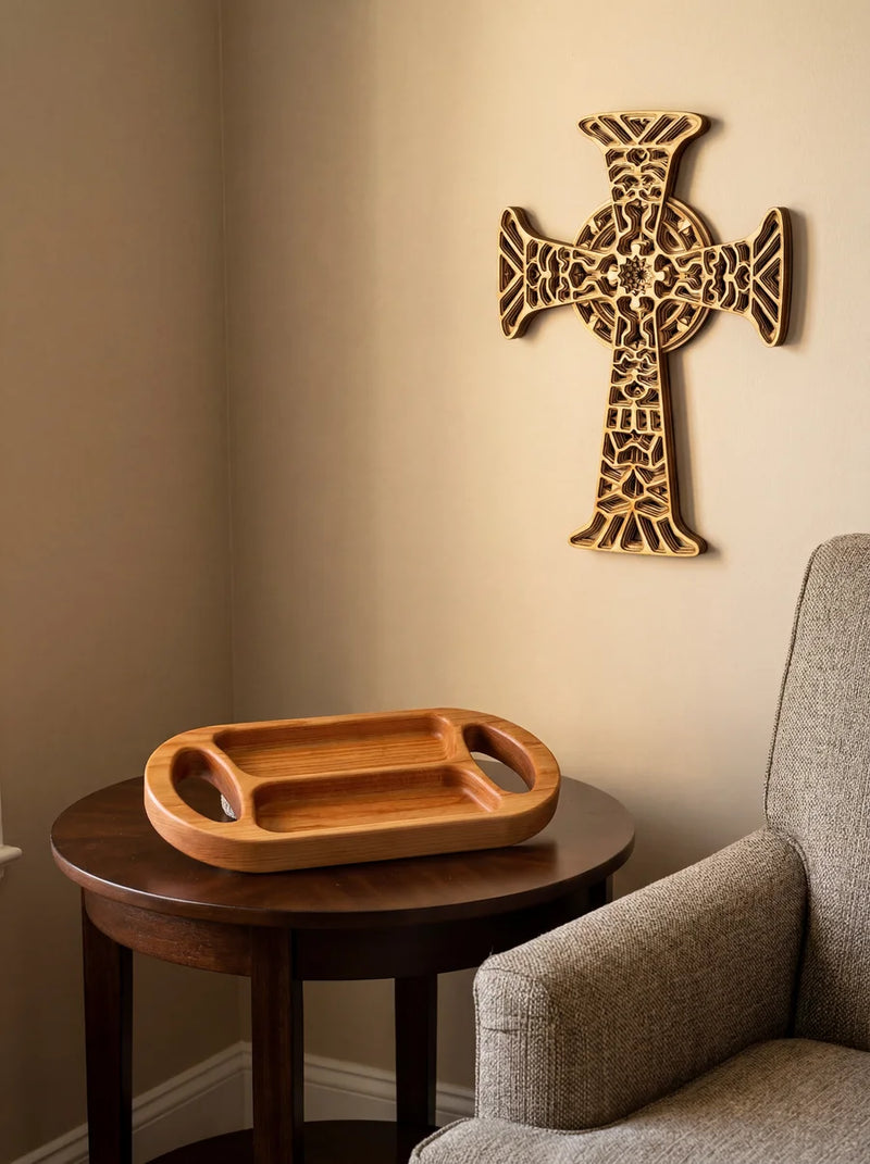Maple serving tray on round side table in cozy living room corner with ornate wood wall cross on beige wall.