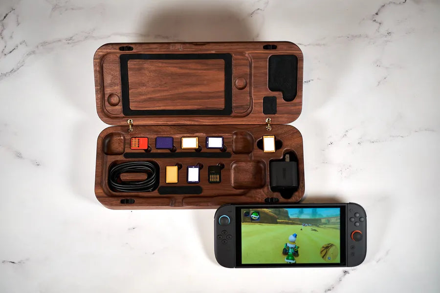 Walnut travel case open on a marble counter with a Nintendo Switch 2 inside.