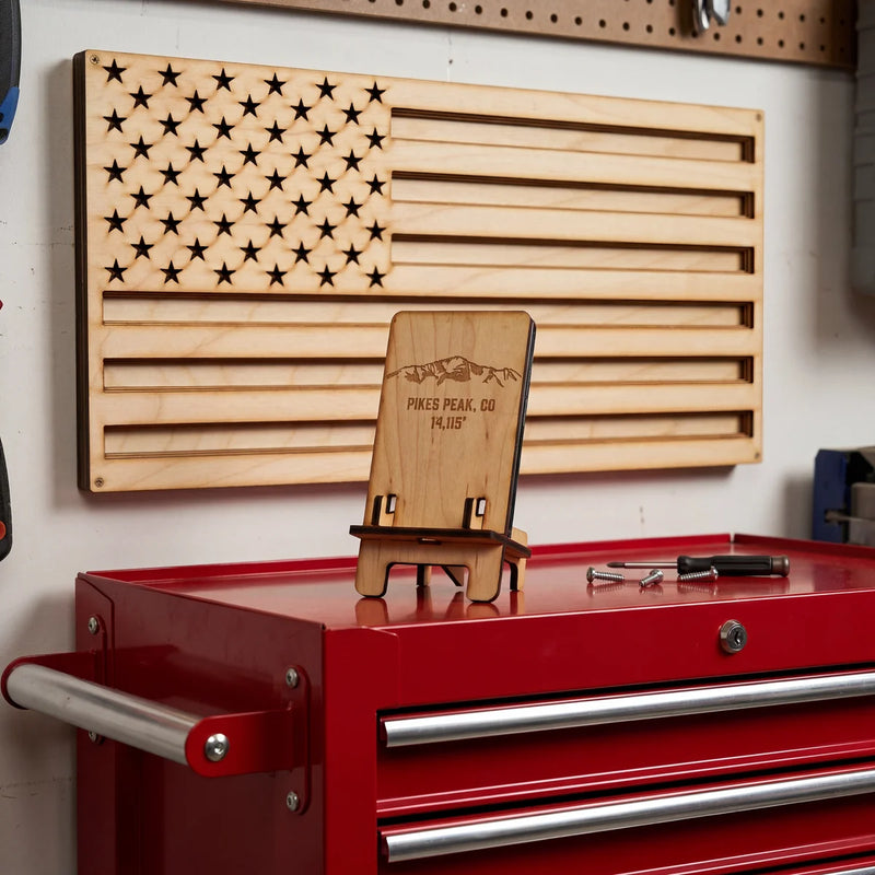Wood phone stand on red toolbox with wood American flag wall art on wall in workshop.
